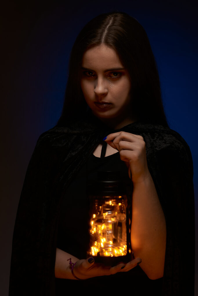 Femme tenant une lanterne, vêtue d'une robe noire, portrait onirique