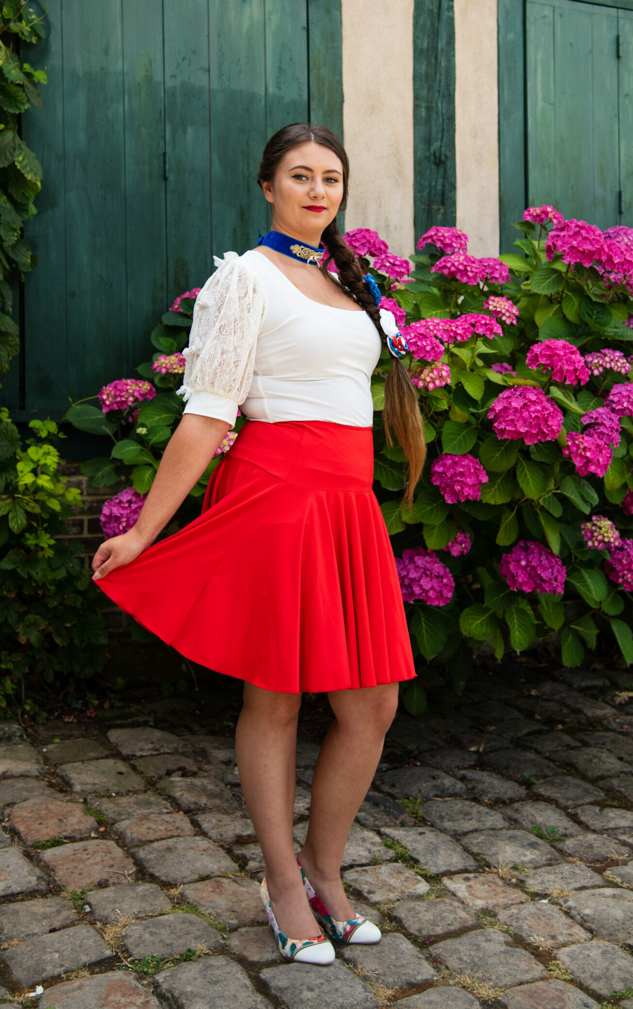 Modèle portant un top blanc et une jupe rouge, de la marque "cherry et dandy"